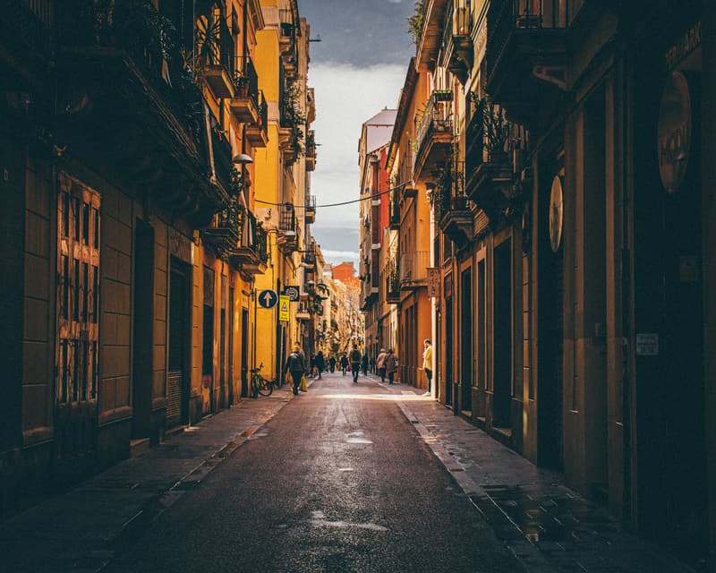 A narrow street in Barcelona lined with buildings and balconies